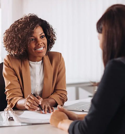 Two women are sitting at a table talking.