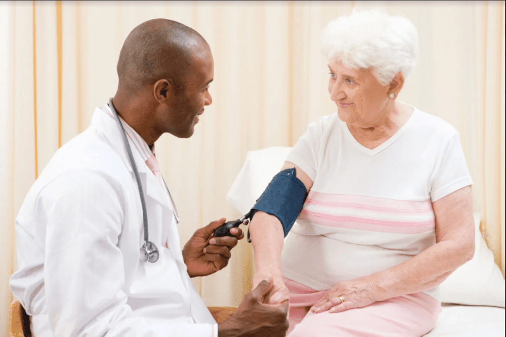 A doctor is checking the blood pressure of an older woman.